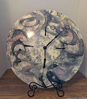 Large round pottery clock face showing abstract swirled pattern with clock hands, 16 inch diameter