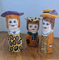 Front view of the three ceramic items: two salt and pepper shakers and one vase, all with distinctive female figure designs and colorful painted details.