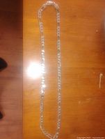 Full view of .925 sterling silver men's mariner link chain necklace laid flat on wooden surface.