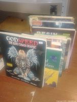 Photo showing a collection of approximately eight books with 'Godspeed: The Kurt Cobain Graphic' prominently visible in front.
