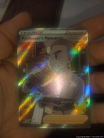 Photo of full art holofoil Pokémon card showing Professor Oak holding a drink with rainbow foil shine.