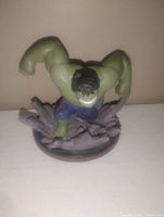 Front view of green Hulk action figure posed on gray rubble base.