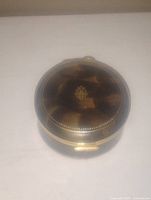 Top view of Italian vintage compact showing tortoiseshell patterned lid with gold beaded border and central emblem.