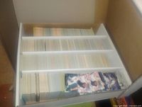Baseball cards organized in a white divided storage box, showing top view of numerous cards tightly packed.