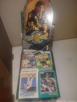 Opened Mario-themed box showing multiple sports cards inside plastic sleeves, prominently featuring a premium hockey card with a player in a Pittsburgh Penguins uniform.