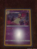 Photo showing holo foil Typhlosion Pokémon card with some reflection on surface.