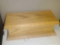 Two images showing a light oak wood rectangular box with a hinged lid, no visible ornamentation, in good condition.