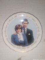 Photo of the vintage commemorative plate showing Charles and Diana in color with gold script text around the edge.