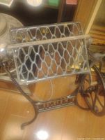 Cast iron base with lattice-style pedal and large spoked wheel on side, showing the sturdy frame with "SINGER" cast logo.