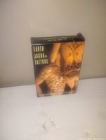 Front view of the Earth Jagua Tattoos box showing the branding and sample tattoo designs.