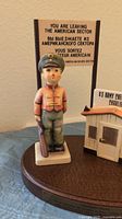 Full view of the Checkpoint Charlie figurine with soldier, guardhouse, and sign showing the historical quote and multi-language sign.