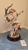 Full front view of the porcelain sculpture on wood base with lot number card visible