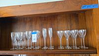 Full set of Lenox Firelight stemware with 8 wine glasses, 4 flutes, and 4 goblets arranged on a wooden shelf