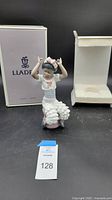 Full view of the Lladró porcelain figurine standing in front of the original box and styrofoam packaging.