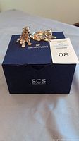 Both leopard cub figurines displayed on top of blue Swarovski box