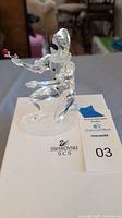 Kneeling Swarovski crystal Harlequin figurine holding a red rose, displayed on original packaging box with auction tag.