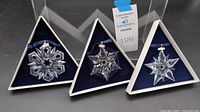 Front view of all three boxed Swarovski snowflake ornaments (1999, 2000, 2001)