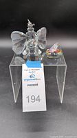 Front view of Dumbo figurine with Cinderella's slipper on clear acrylic stand with auction tag