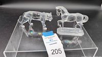 Full view showing both Swarovski crystal figurines including a tiger and a stallion on a reflective surface.