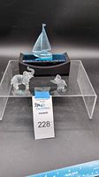 Overview of three crystal figurines: sailboat on stand and two elephants