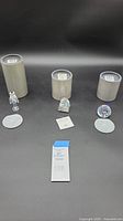 Overall display of three Swarovski crystal figurines with original packaging and certificates.