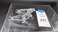 Two clear Swarovski crystal walrus figurines displayed in original plastic box with Maxsold lot number label visible.