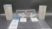 Two Swarovski Silver Crystal ducks displayed with original cylindrical packaging and certificates of authenticity.