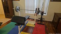 Front view of bench in flat position with Olympic bar loaded on rack