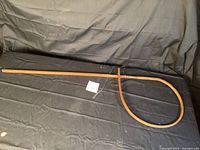 Full view of the wooden railway message hoop showing the circular hoop and long handle resting on a dark fabric background.