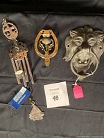 Shows entire lot: wind chime, horseshoe door knocker, lion door knocker, and pewter frame.
