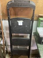 Front view of the black Gorilla 3-step ladder showing the top handle with logo and the three wide steps.