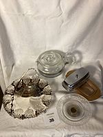 All items displayed together: Pyrex tea pot, two serving trays, butter dish with wooden base and silver lid.