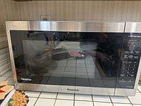Front view of Panasonic microwave oven showing glass door and stainless steel frame.