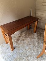 Side view of the wooden console table showing leg design and finish.