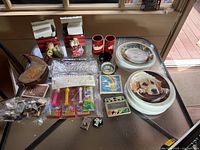Top-down photo showing assorted collectibles including Pepsi and Coca-Cola items, matchboxes, memorabilia, and plates.