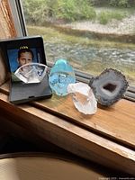 Overall lot showing blue glass egg, Mats Jonasson horse, two crystals, agate slice on windowsill