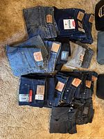 Overhead view of folded jeans piles displaying mix of indigo, black and grey washes