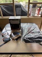 Overview of all items on table: boxed reversible grill cover, two microfiber car wash pads, and new tarp in plastic wrap.