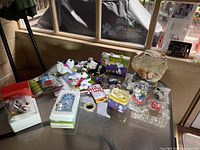 Overview of Peanuts collectibles on glass table including figurines and plaques in packaging and foam.