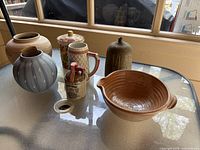 Group photo showing all pottery pieces on a glass table by a window