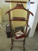 Full view of vintage walnut valet stand showing hanger, tray, and frame.