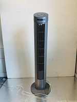 Full view of the Seville Classics oscillating tower fan showing height, slim design, grey color, round base, and vertical vents.