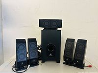 Front view of the Logitech speaker and subwoofer set, showing four satellite speakers and one subwoofer.