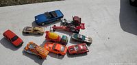 Photo showing 10 diecast cars of various models and colors in 1:64 scale.