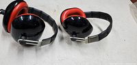 Two pairs of black and red Silenta ear protection muffs side by side on a white surface.