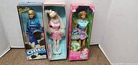 Front view of three Barbie dolls in original boxes: Oreo Barbie, Bride Barbie, and Butterfly Surprise Barbie.