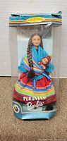 Front of the original Barbie Peruvian doll packaging showing the doll in colorful traditional clothing holding a baby doll.