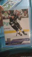 Alex Laferriere Young Guns hockey card in protective sleeve showing player skating in black Kings uniform on ice.