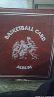 Cover of the brown leather-bound basketball card album with text 'Basketball Card Album' and graphic illustration.
