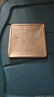 Closed metal case with embossed flying dove and inscription 'Canada 1988 The Rebirth of Peace'